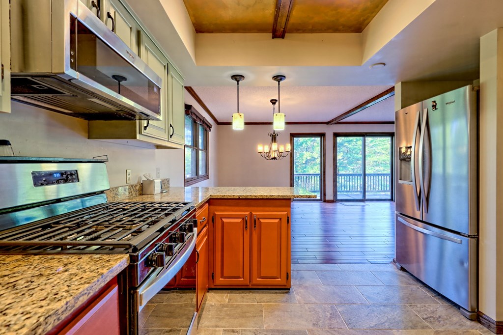 206 Peckerwood Road Hayesville, NC 28904 - Photo 11 of 73 a kitchen with stainless steel appliances granite countertop a stove and a refrigerator