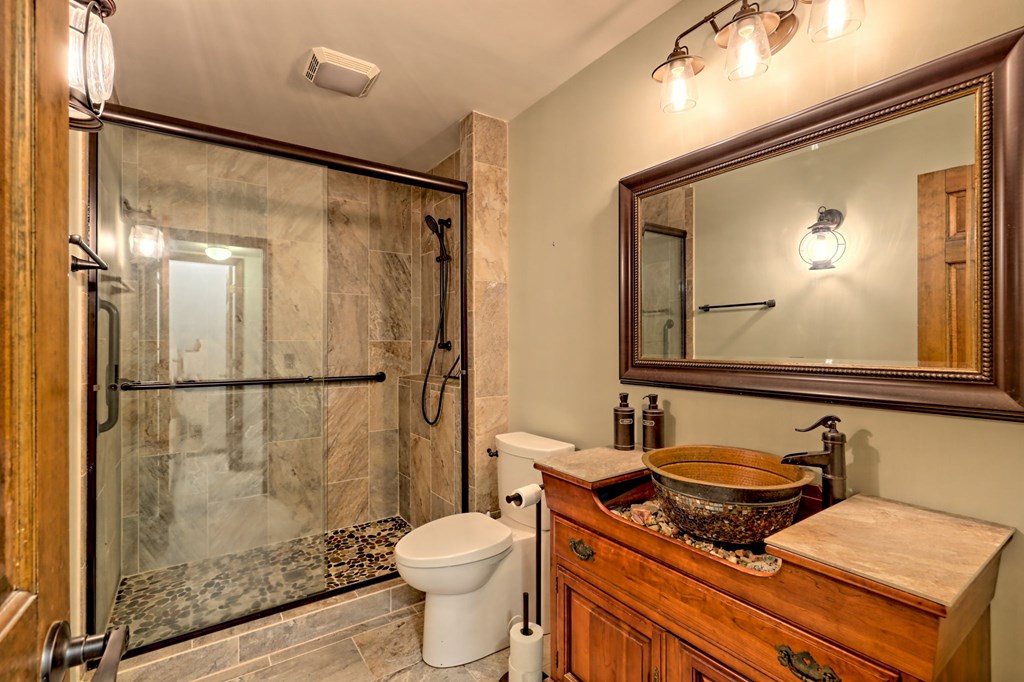 206 Peckerwood Road Hayesville, NC 28904 - Photo 21 of 73 a bathroom with a granite countertop sink mirror vanity and toilet