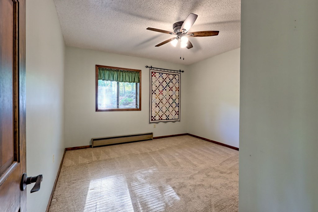 206 Peckerwood Road Hayesville, NC 28904 - Photo 46 of 73 an empty room with chandelier fan and windows
