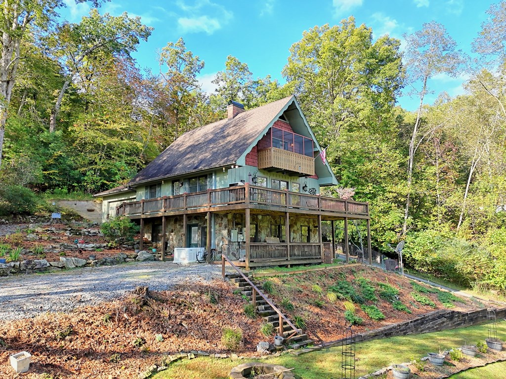 206 Peckerwood Road Hayesville, NC 28904 - Photo 68 of 73 a view of a white house with large windows and a small yard with plants