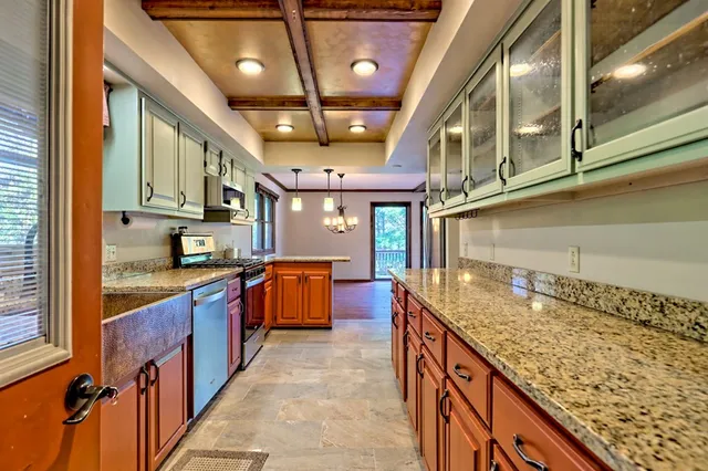 a kitchen with stainless steel appliances granite countertop a sink and a stove