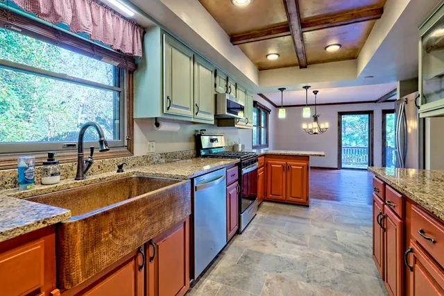a kitchen with stainless steel appliances granite countertop a refrigerator a stove and a sink