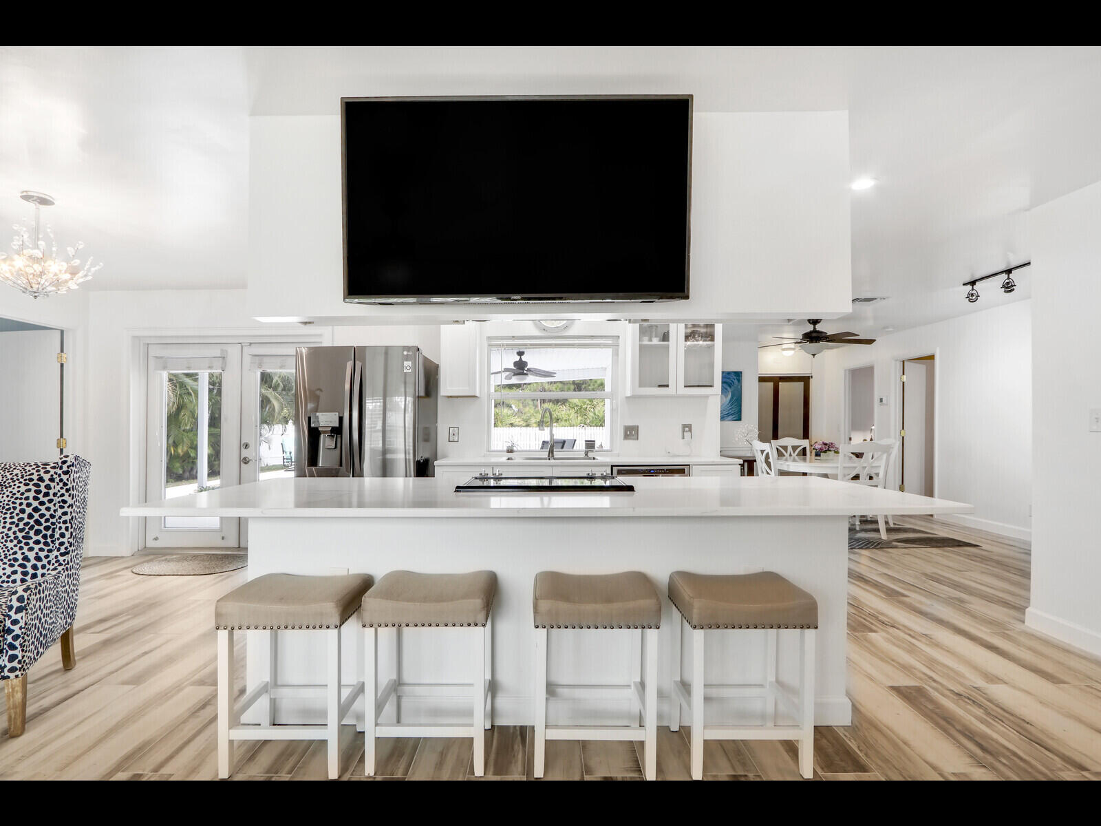 609 Oak Terrace Jupiter, FL 33458 - Photo 9 of 28 a living room with stainless steel appliances kitchen island granite countertop furniture and a flat screen tv