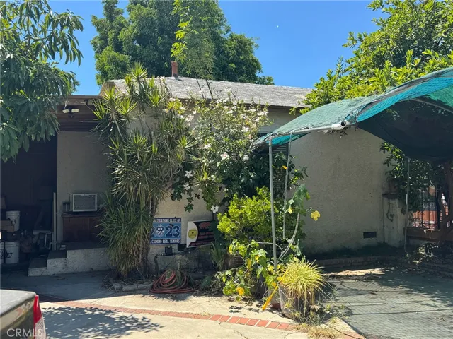 a view of a house with plants and large trees