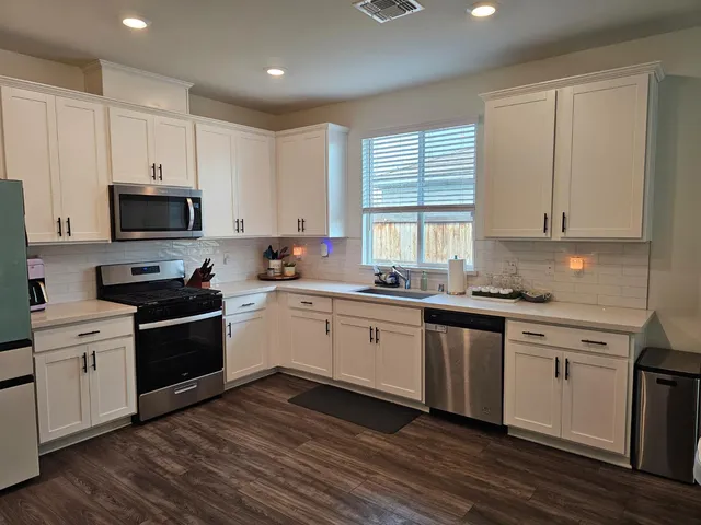 a kitchen with sink a microwave and cabinets