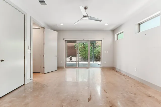 an empty room with closet and a chandelier fan