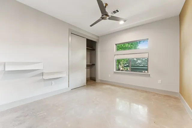 an empty room with windows and closet