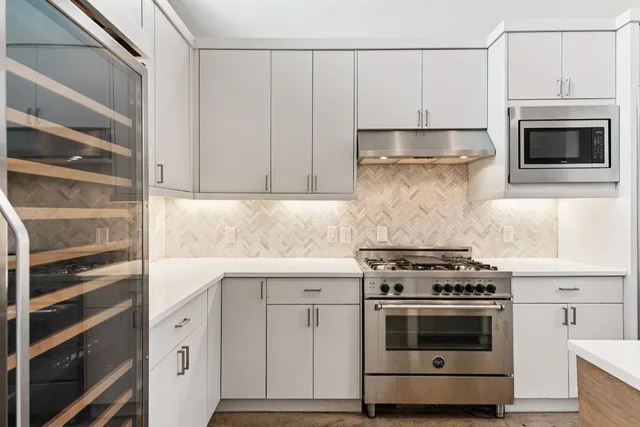 a kitchen with granite countertop white cabinets and white appliances