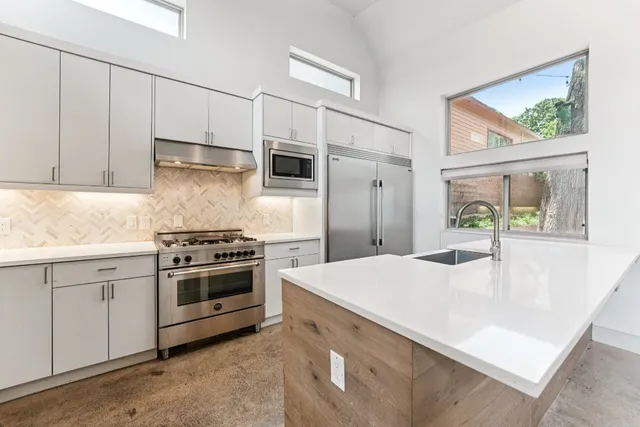 a kitchen with stainless steel appliances a stove a sink and a refrigerator