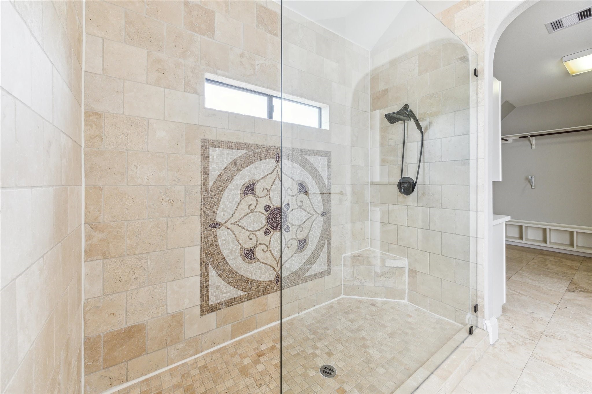 1512 Thompson Street, Unit 3 Houston, TX 77007 - Photo 20 of 32 This elegant bathroom features a spacious walk-in shower with a glass enclosure, decorative tile accent, and a modern shower head. The neutral tile design and built-in bench add functionality and style.
