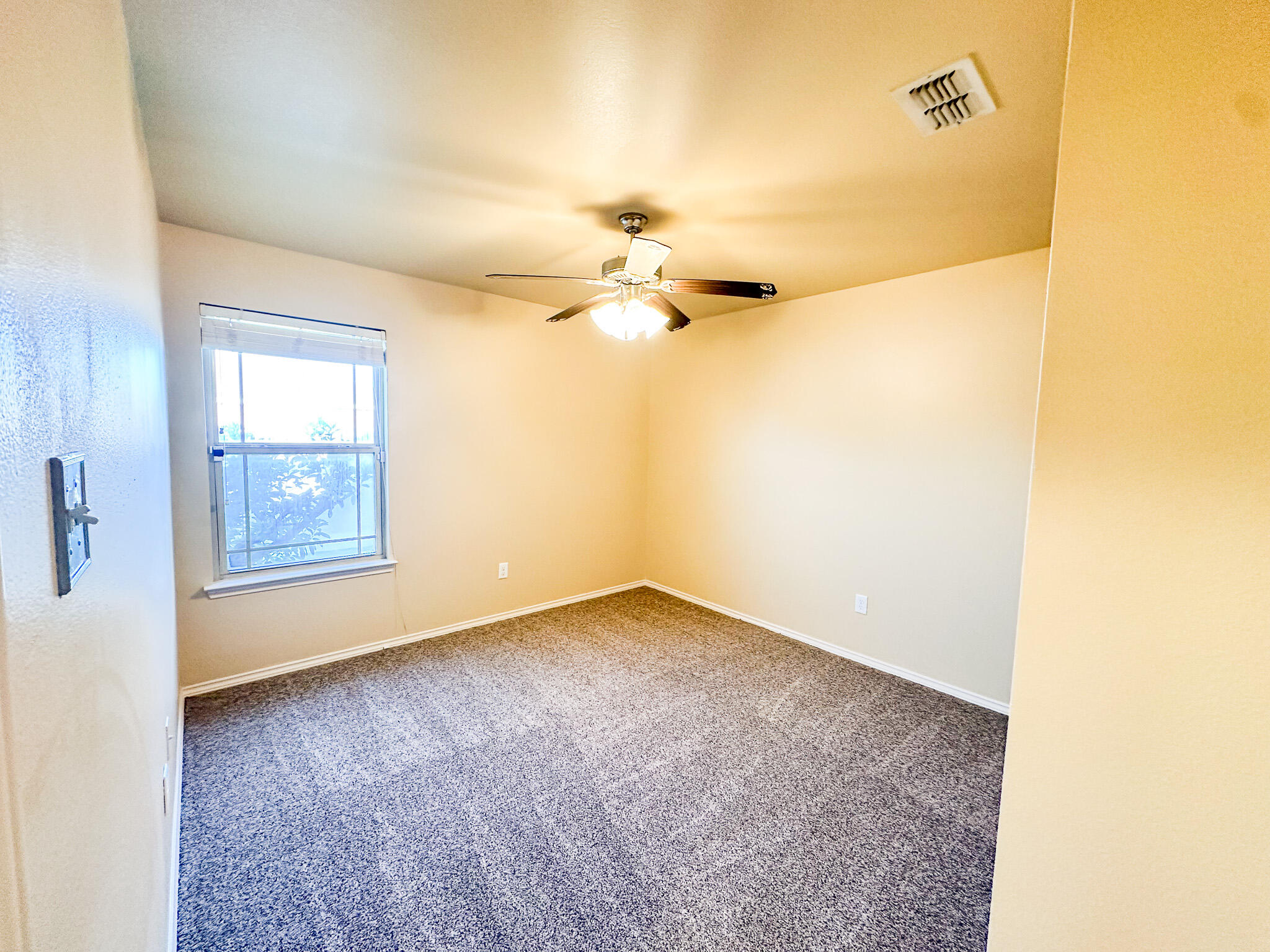 2309 101st Street Lubbock, TX 79423 - Photo 20 of 36 an empty room with a ceiling fan and a window