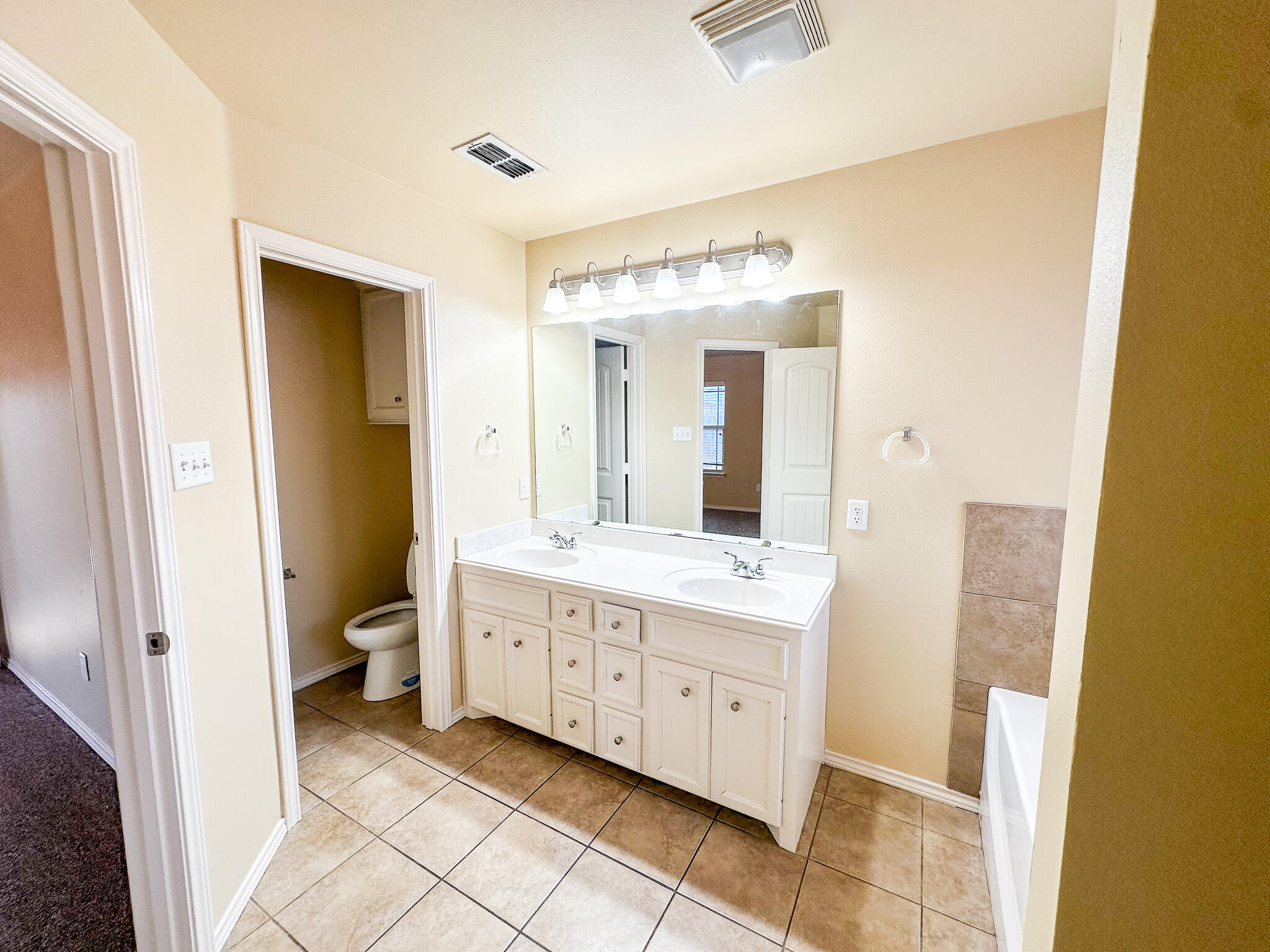 2309 101st Street Lubbock, TX 79423 - Photo 24 of 36 a spacious bathroom with a double vanity sink and a mirror