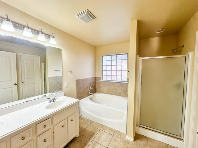 an empty room with windows and ceiling fan