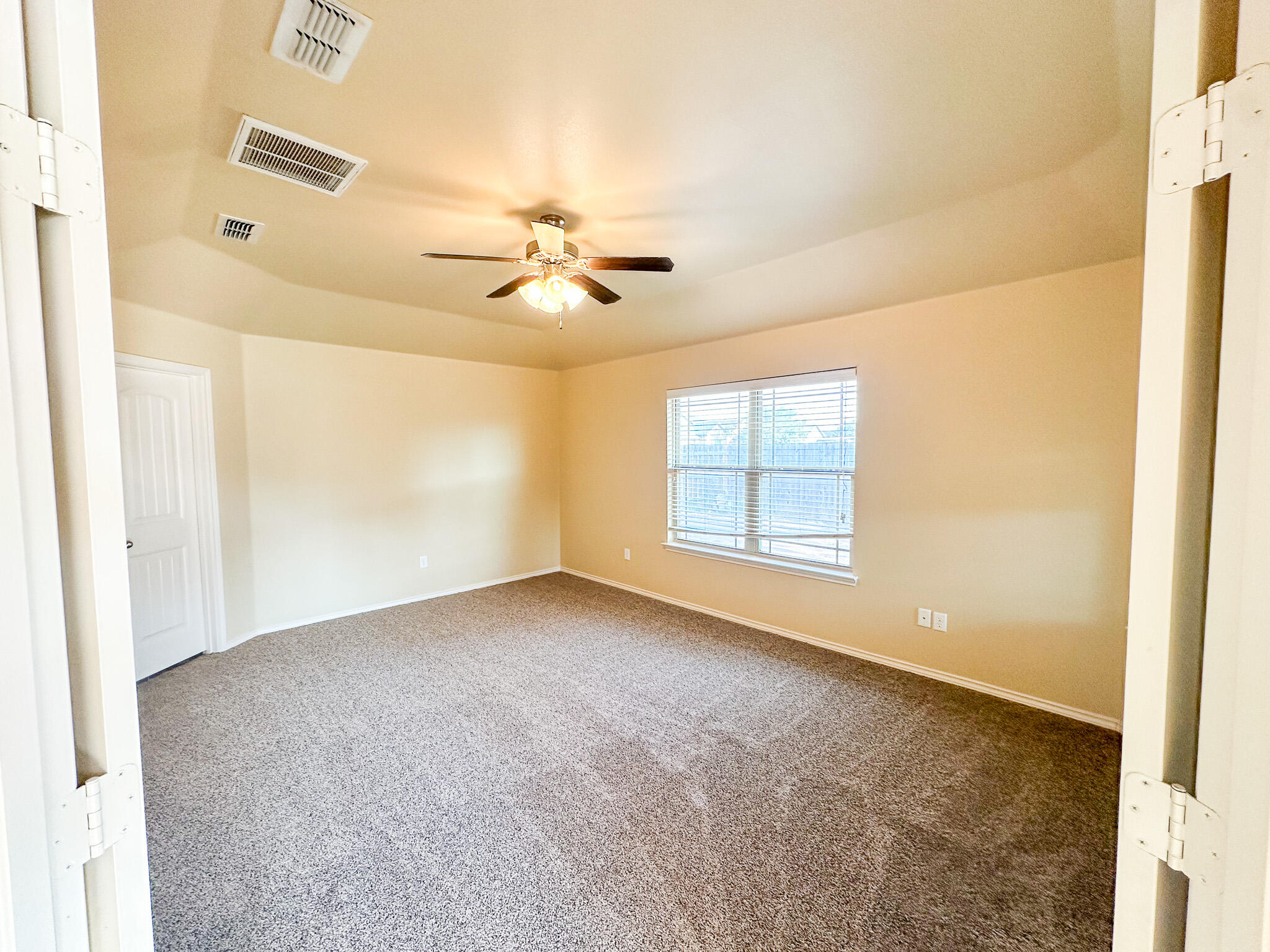 2309 101st Street Lubbock, TX 79423 - Photo 29 of 36 an empty room with windows and ceiling fan