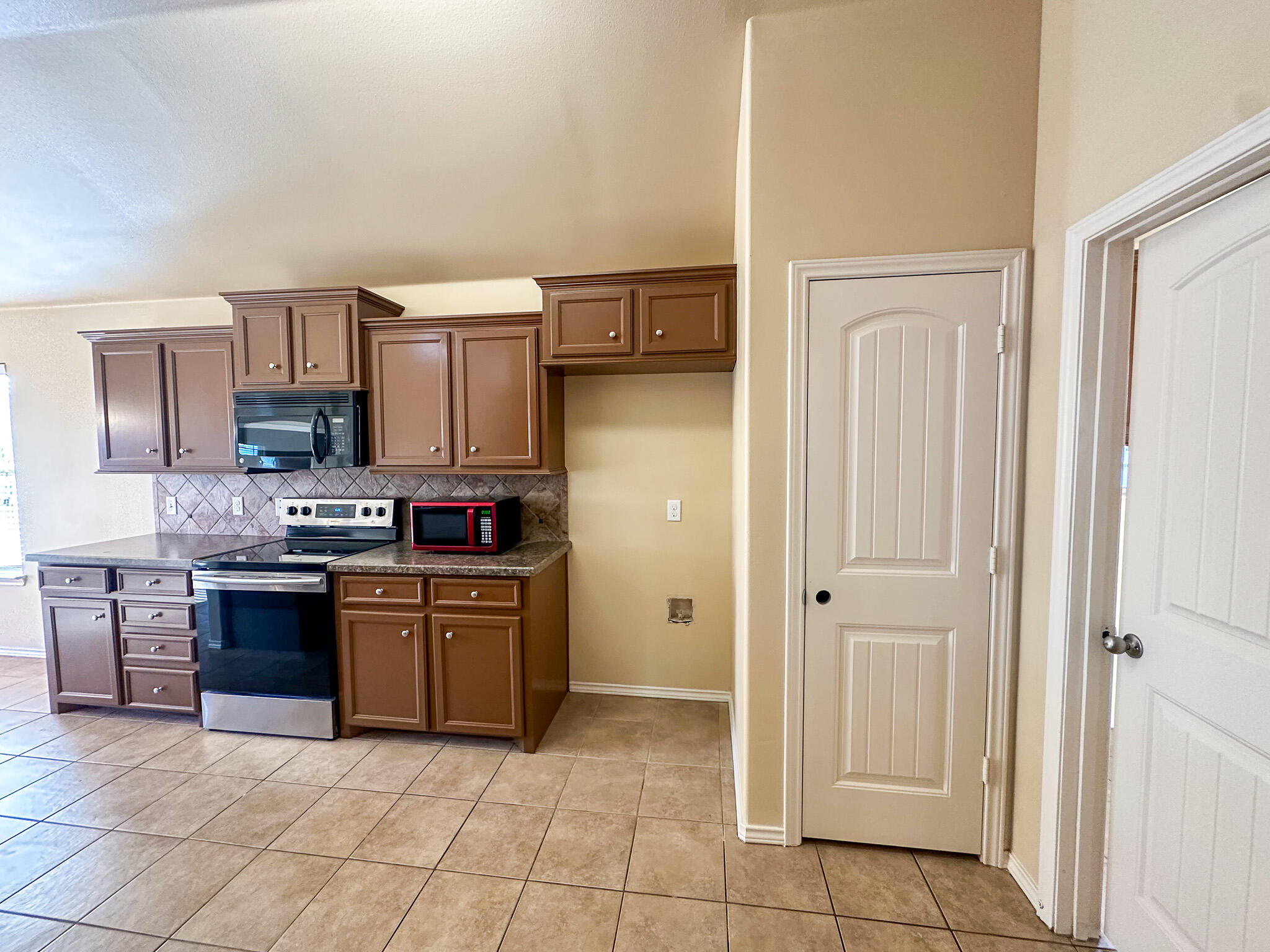 2309 101st Street Lubbock, TX 79423 - Photo 9 of 36 a kitchen with granite countertop a refrigerator and a stove top oven