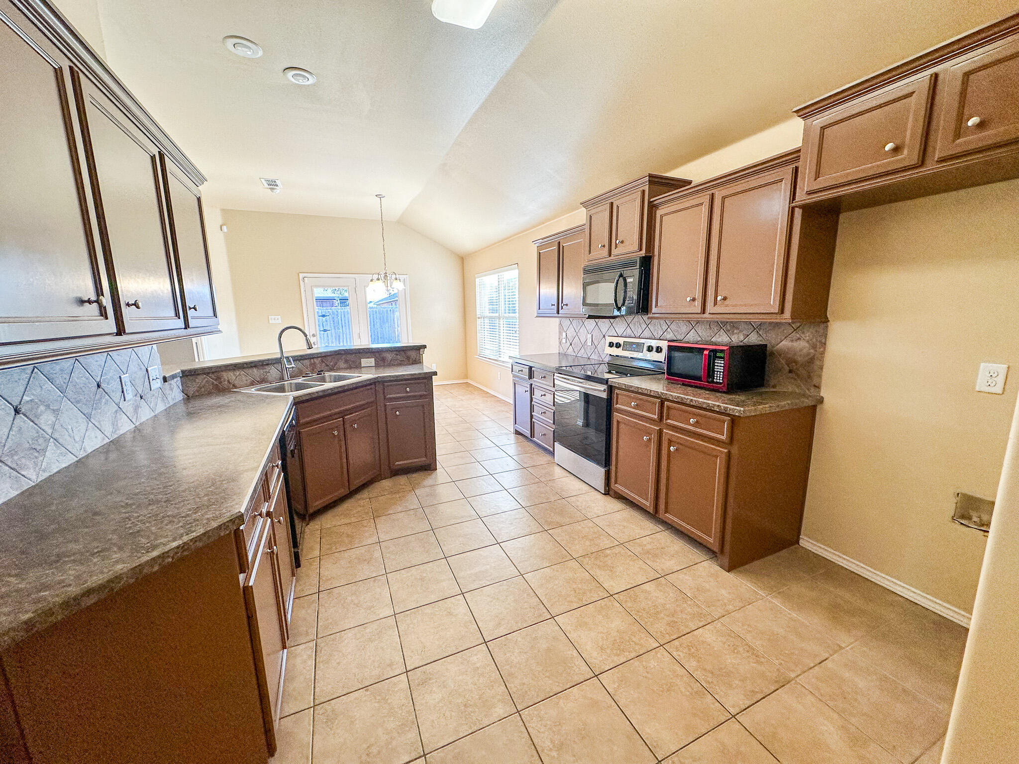 2309 101st Street Lubbock, TX 79423 - Photo 10 of 36 a kitchen with stainless steel appliances granite countertop a sink stove and cabinets