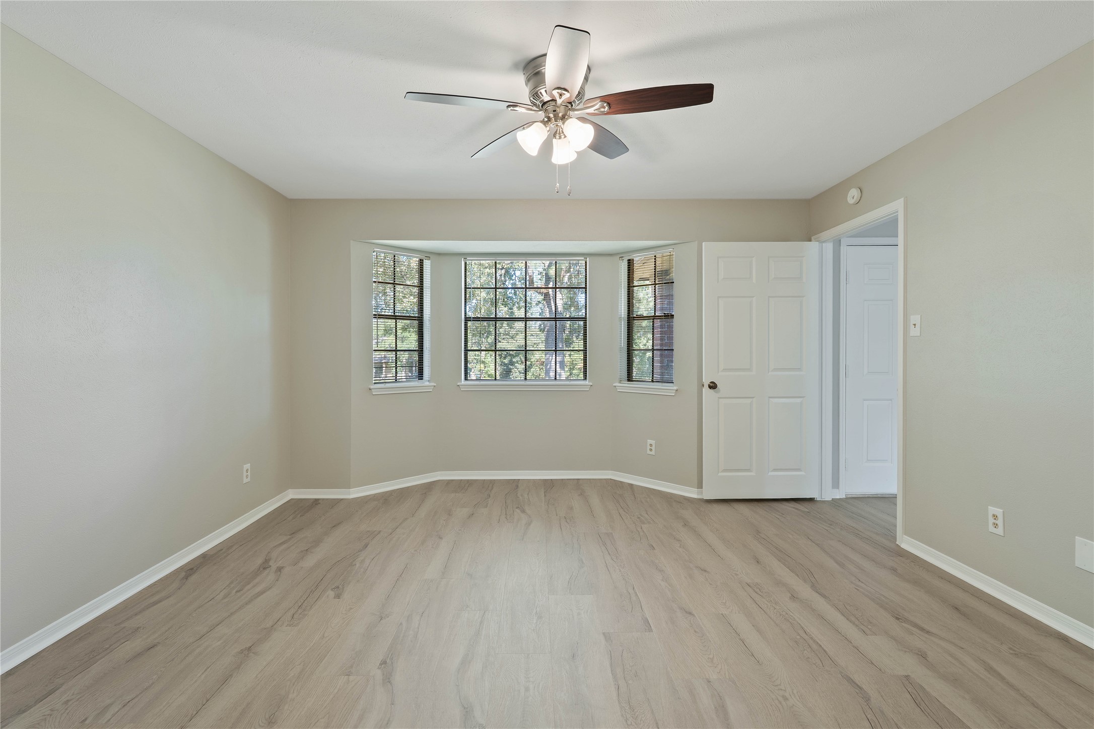 200 Panorama Drive, Unit 107 Conroe, TX 77304 - Photo 20 of 32 wooden floor in an empty room with a window