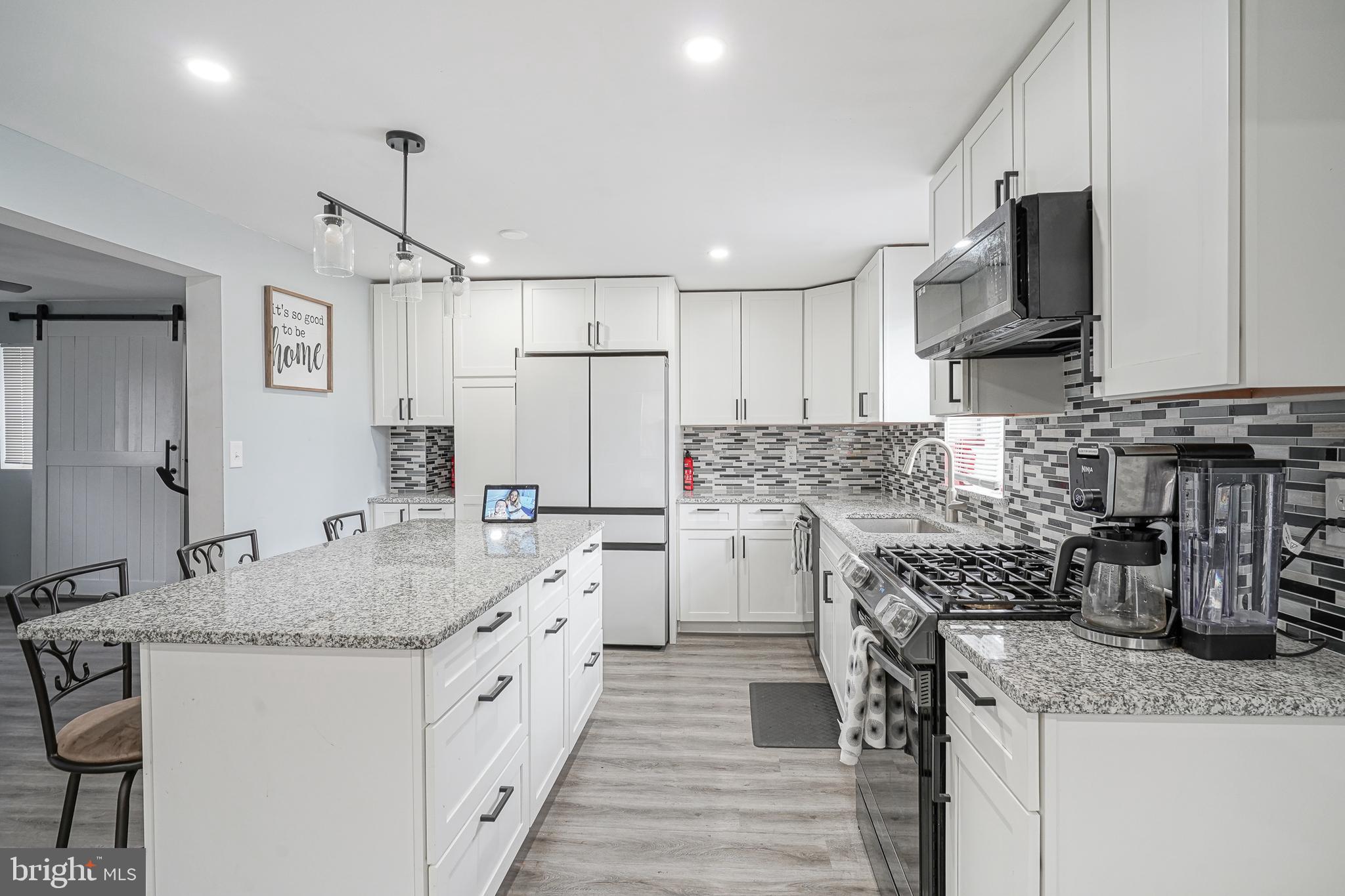 a kitchen with white cabinets sink and stainless steel appliances