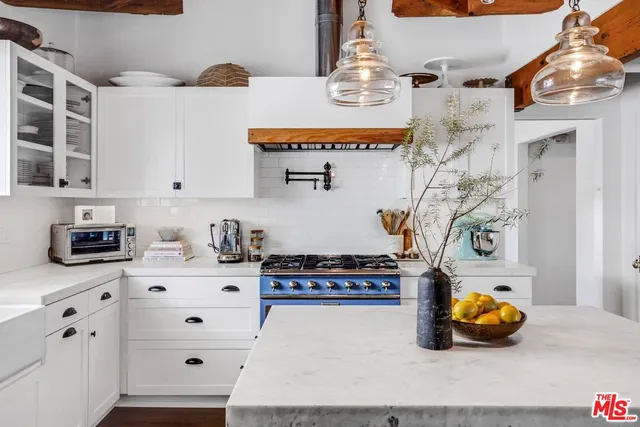 a kitchen with cabinets wooden floor and stainless steel appliances