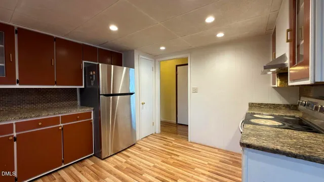 a kitchen with stainless steel appliances granite countertop a refrigerator and a sink