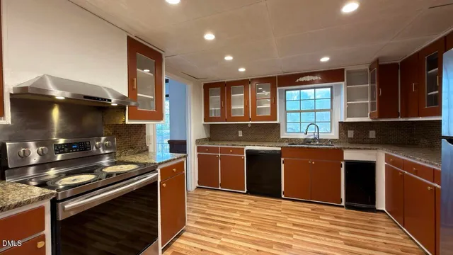 a kitchen with stainless steel appliances granite countertop a stove and a sink