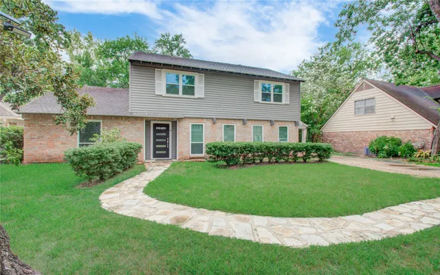 a view of a house with a yard and potted plants