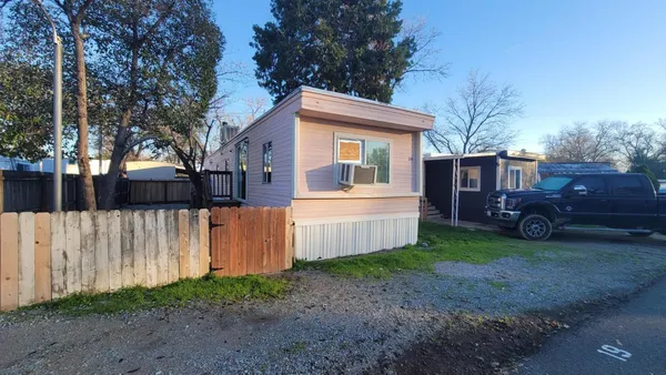a front view of a house with a garden and trees