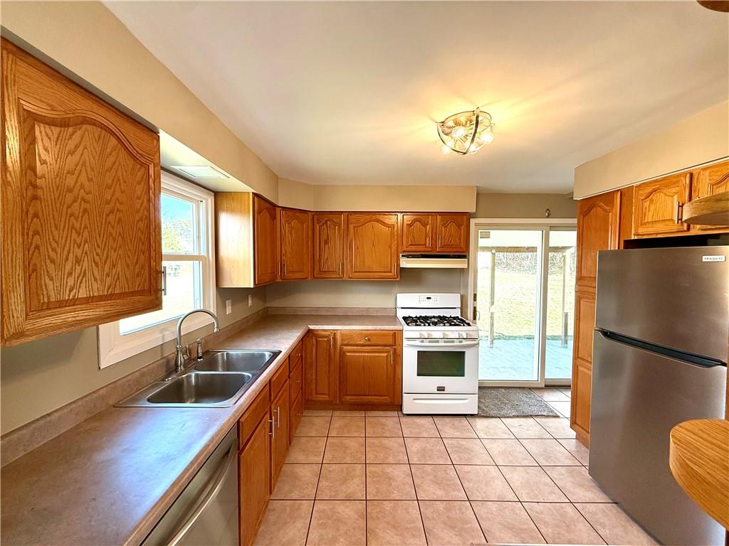 2118 Brodhead Road Aliquippa, PA 15001 - Photo 7 of 35 a kitchen with stainless steel appliances granite countertop a refrigerator a sink dishwasher a stove with wooden cabinets and floor