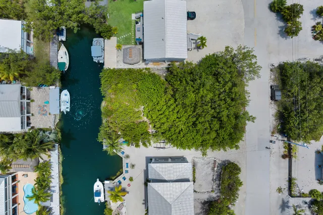an aerial view of a house with a yard and garden in front of it