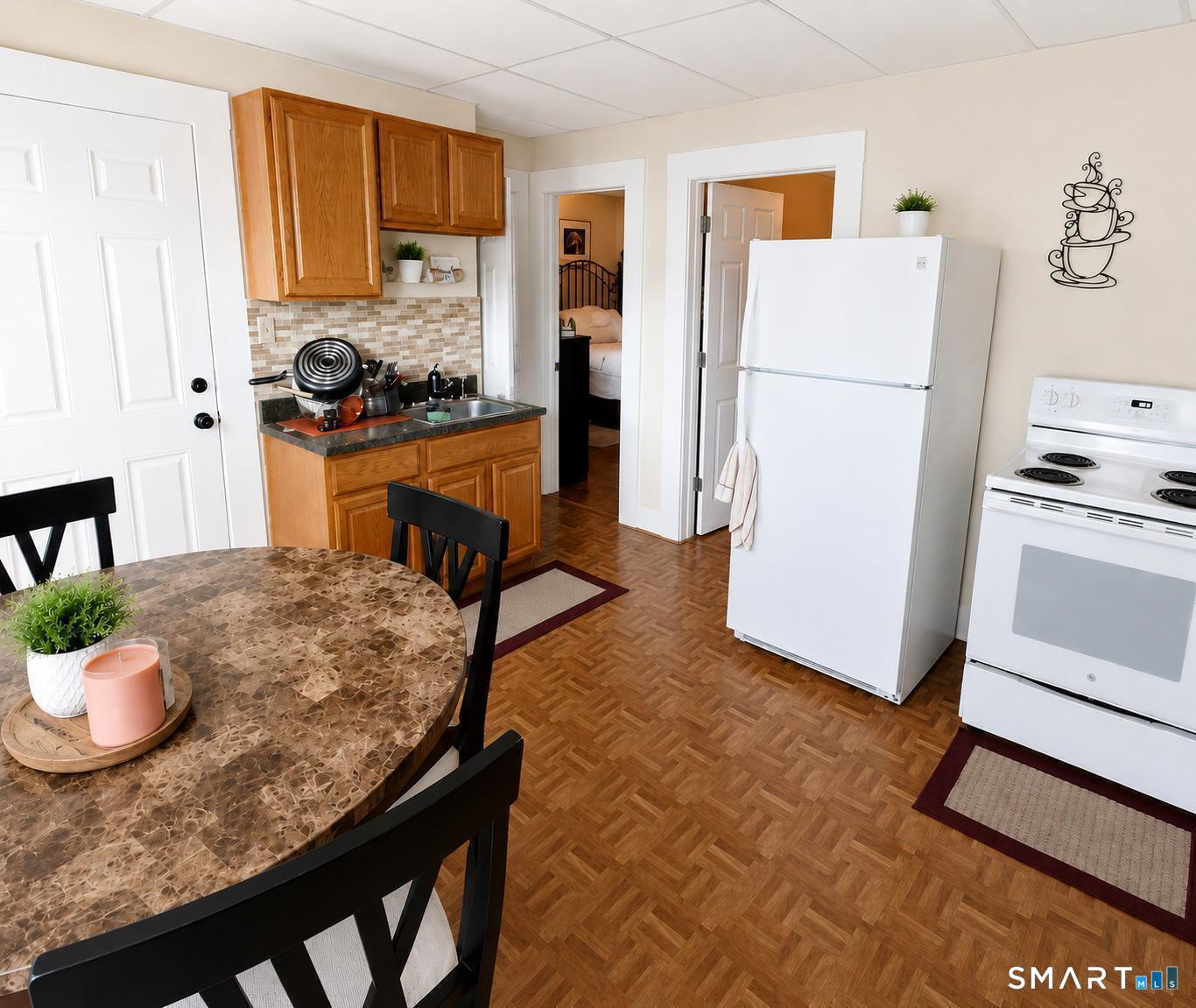61 Bartlett Street Meriden, CT 06451 - Photo 17 of 30 a kitchen with granite countertop a refrigerator a stove a sink a dining table and chairs