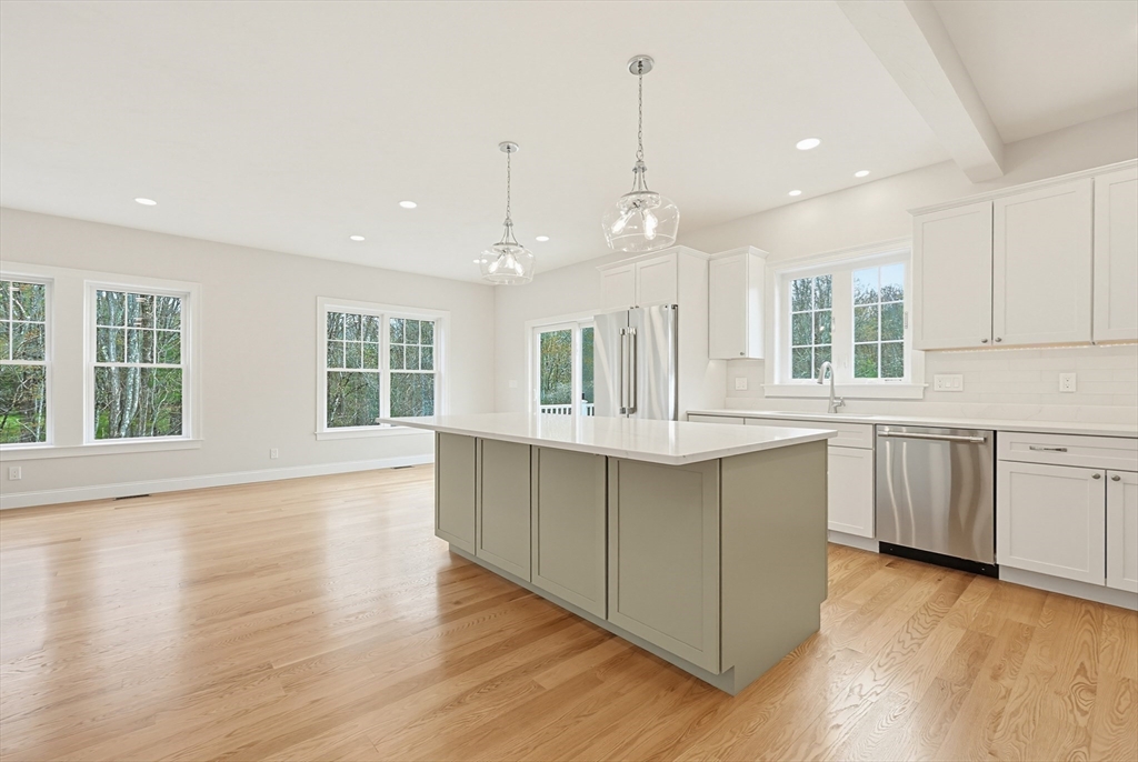 889 Maple Street Mansfield, MA 02048 - Photo 11 of 42 a large kitchen with kitchen island a large counter top space a sink stainless steel appliances and cabinets