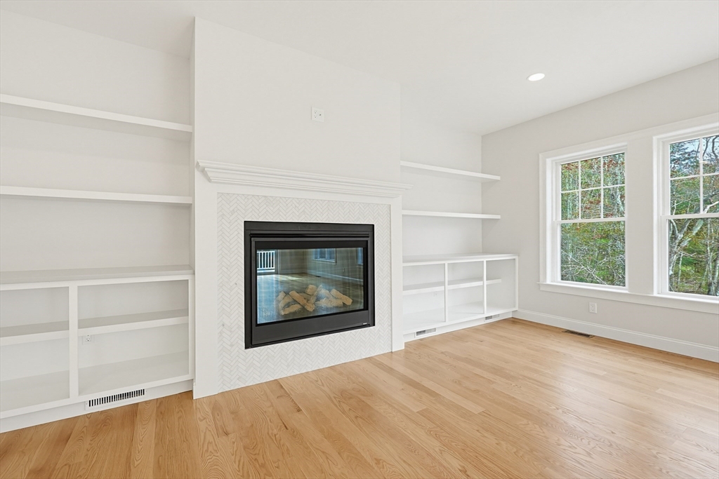 889 Maple Street Mansfield, MA 02048 - Photo 21 of 42 an empty room with a fireplace and wooden floor