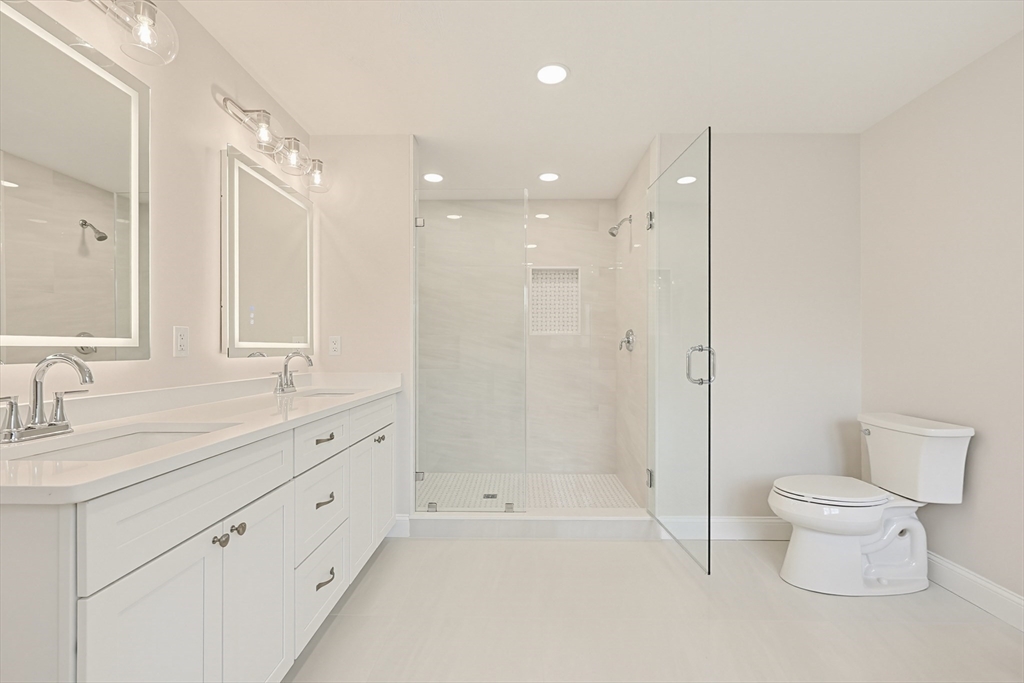889 Maple Street Mansfield, MA 02048 - Photo 26 of 42 a bathroom with a double vanity sink toilet mirror and bathtub