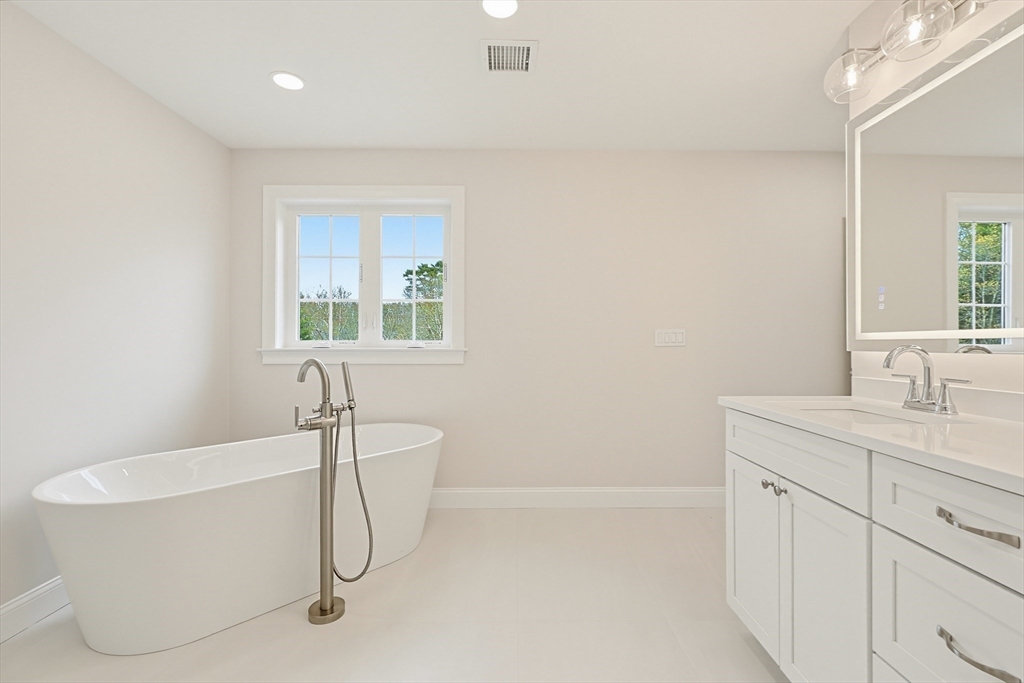889 Maple Street Mansfield, MA 02048 - Photo 27 of 42 a bathroom with a sink a bathtub and a window