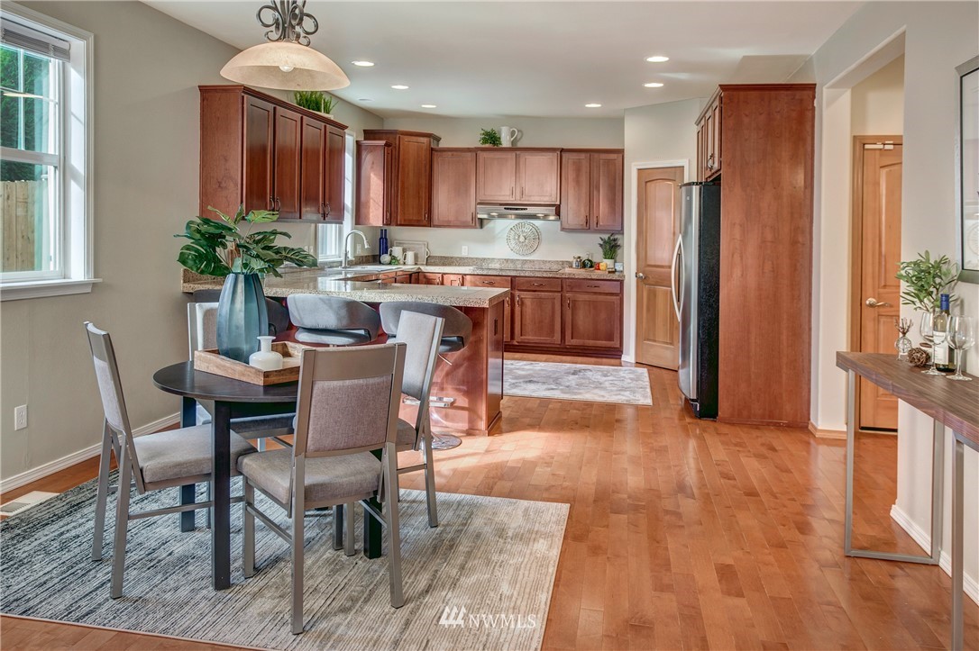 6709 Southeast 2nd Place Renton, WA 98059 - Photo 12 of 25 a kitchen with stainless steel appliances granite countertop a refrigerator a stove a sink dishwasher and white cabinets with wooden floor