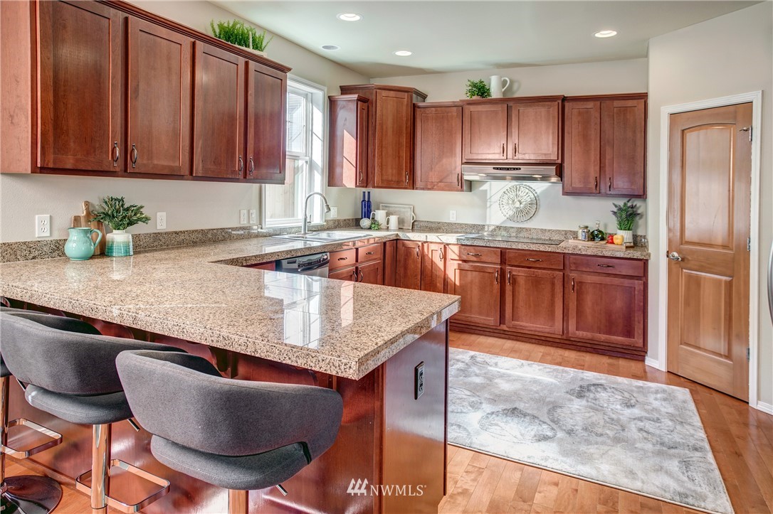 6709 Southeast 2nd Place Renton, WA 98059 - Photo 13 of 25 a kitchen with granite countertop a sink a stove and a refrigerator