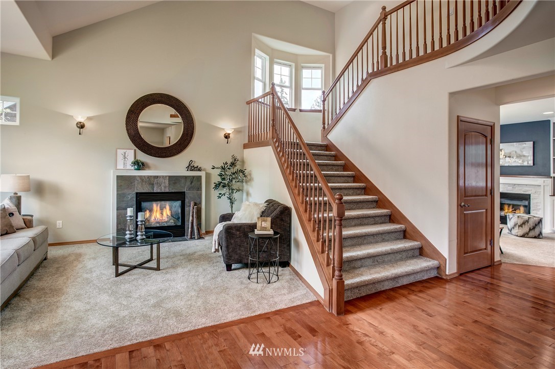 6709 Southeast 2nd Place Renton, WA 98059 - Photo 4 of 25 a view of a livingroom with furniture a fireplace chandeliers fan