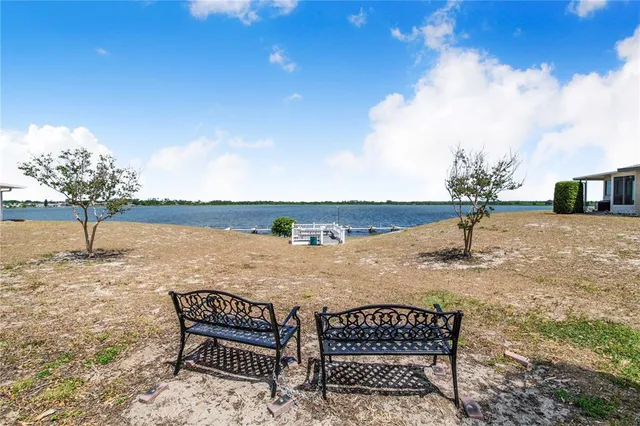 a view of a lake with table and chairs