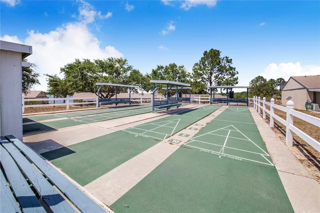 a view of a tennis ground with large trees