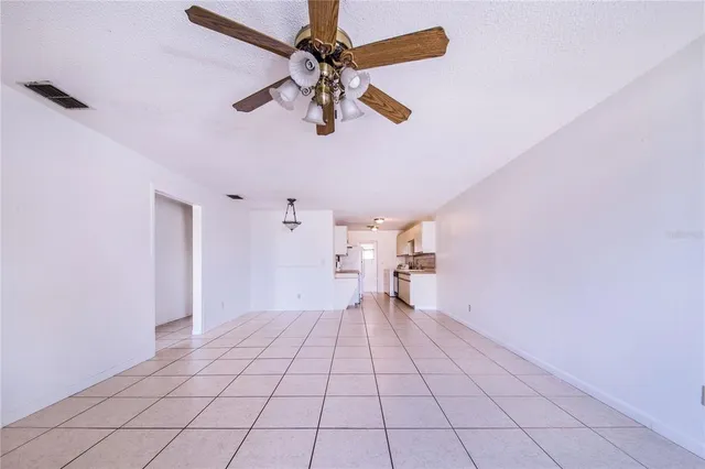 a view of an empty room and a ceiling fan