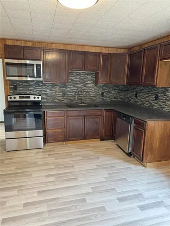 a kitchen with stainless steel appliances granite countertop a sink and wooden cabinets