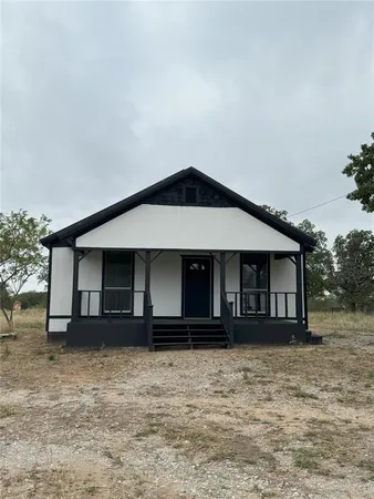 a view of a house with a large window and a yard