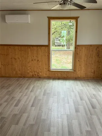 an empty room with wooden floor and a window