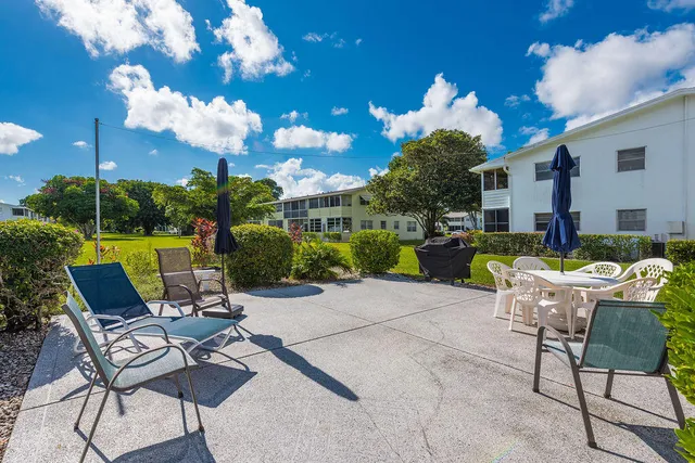 a view of a patio with a table chairs and a fire pit