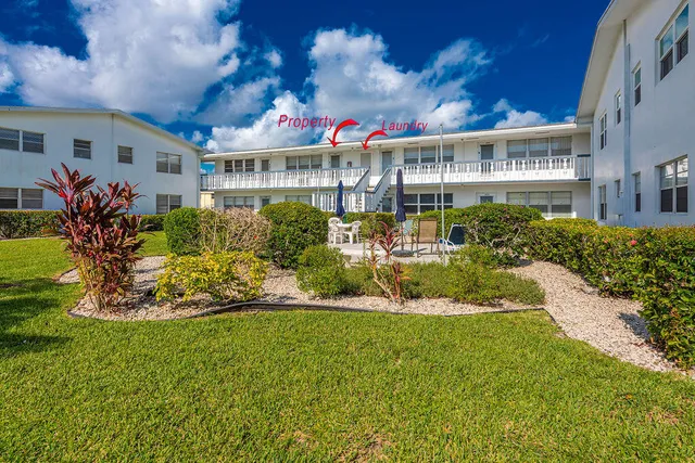 a front view of a multi story residential apartment building with yard and retail shops