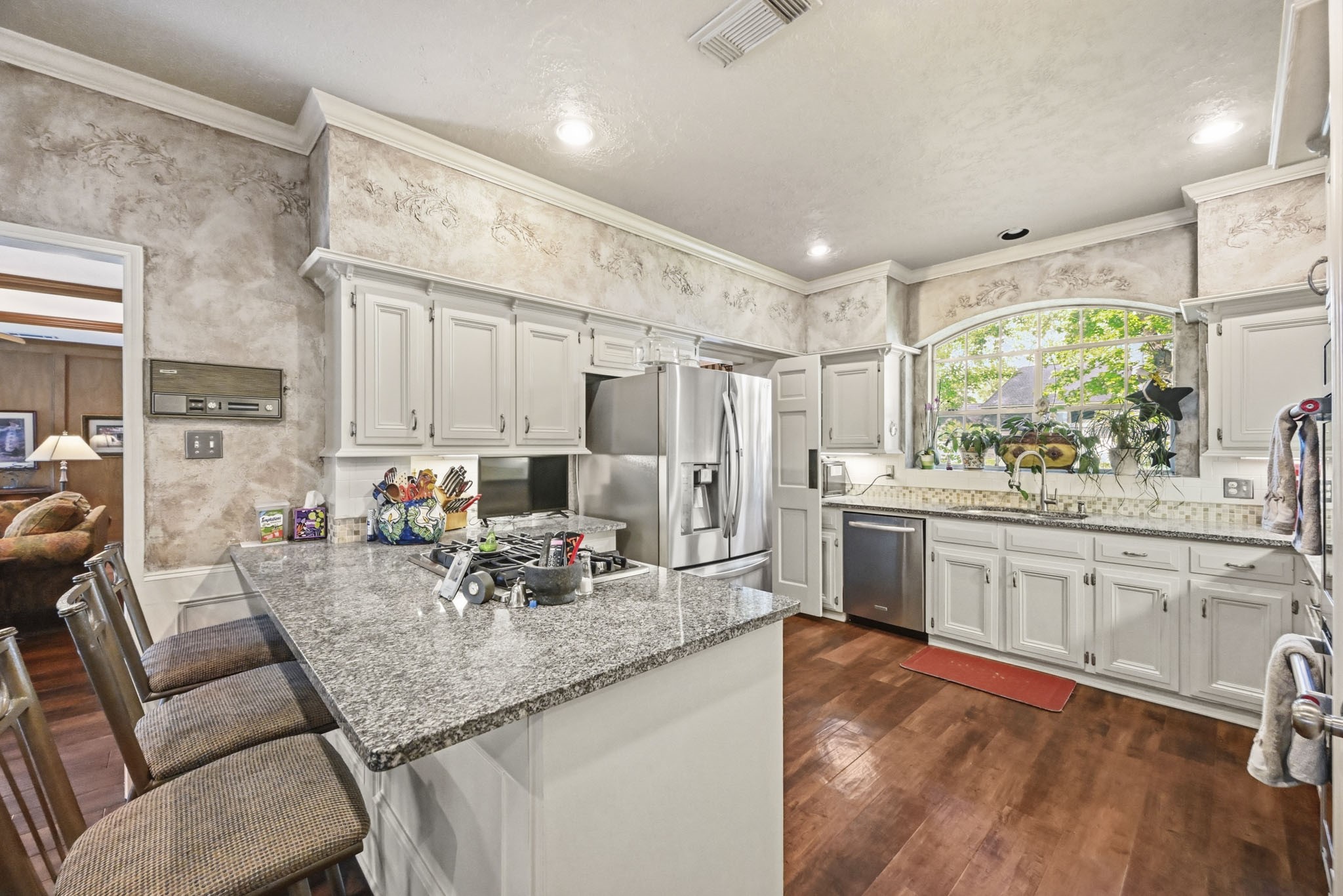 16030 Rudgewick Lane Spring, TX 77379 - Photo 16 of 50 The kitchen has been remodeled twice, the first time to remove soffits and open the room, put in French doors to the backyard, put in the Palladian window over the sink, add canned lighting,. The second remodel saw granite counters, stainless appliances, new cabinet hardward, tile backsplash.