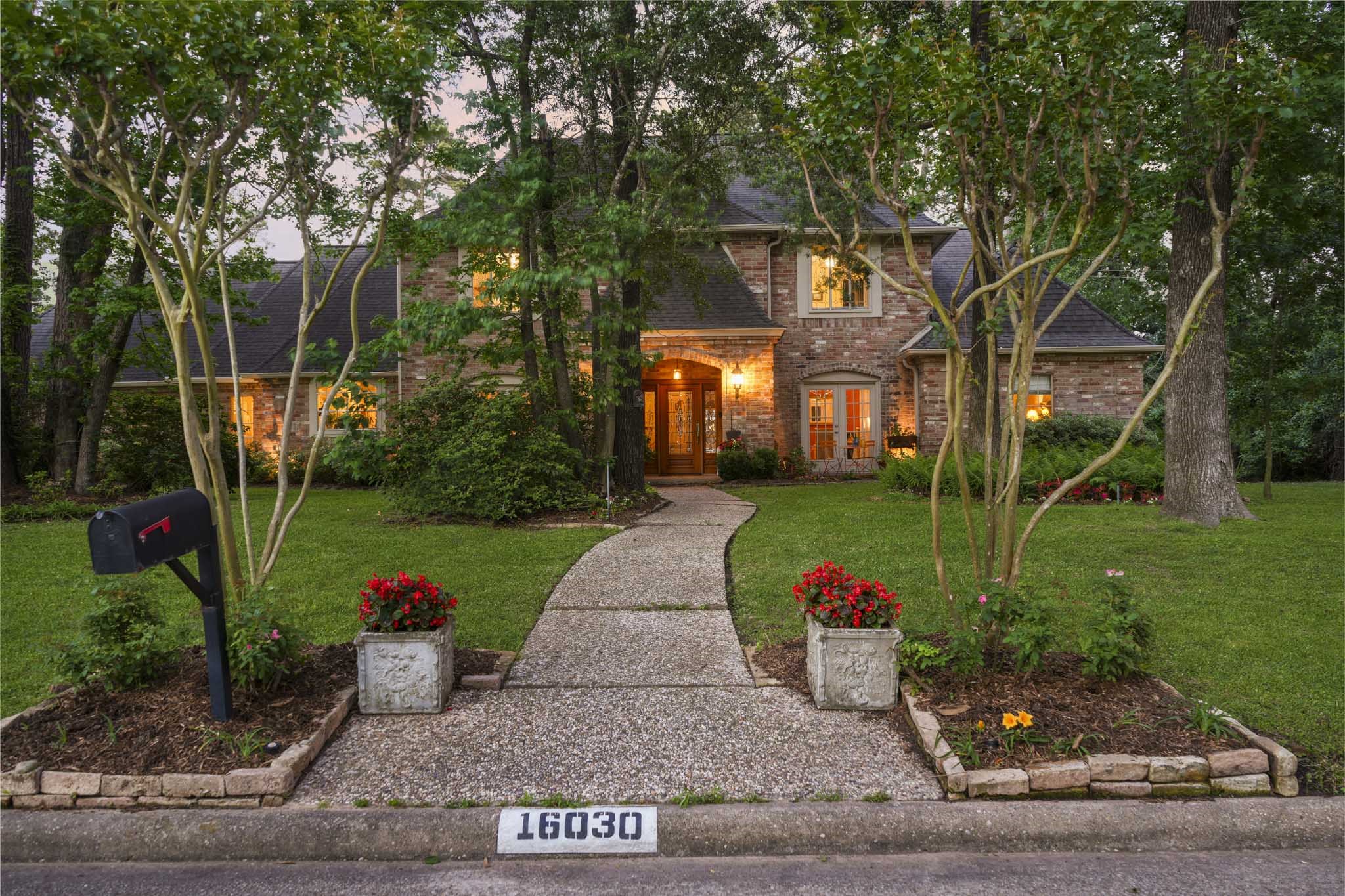 16030 Rudgewick Lane Spring, TX 77379 - Photo 4 of 50 A wide, green yard, planting beds, fun seating in front of the French doors, foundation lighting says welcome to our home. The riot of color from the mature azaleas is just over, the crepe myrtles will be making an appearance soon.