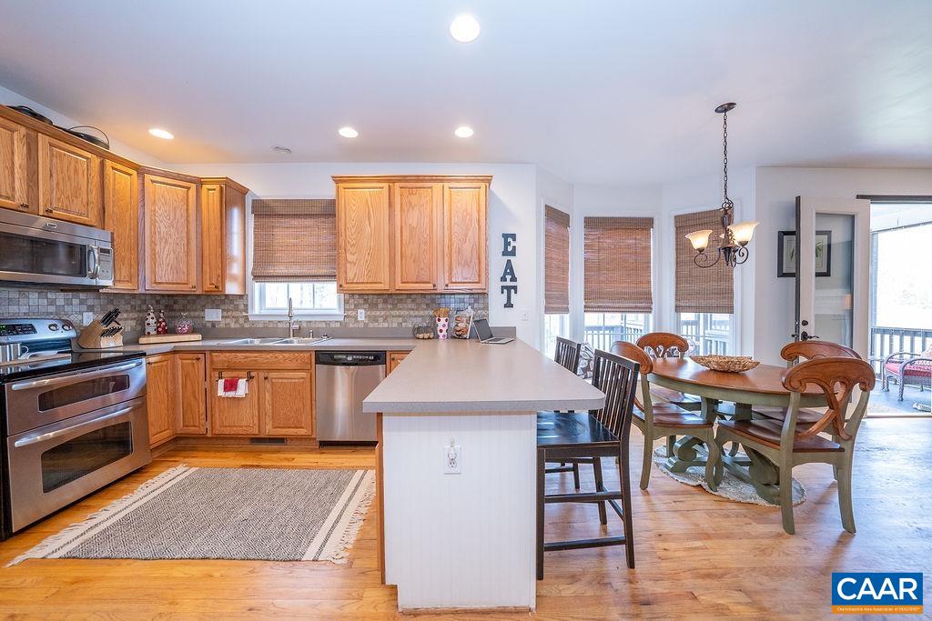 60 Pine Ridge Road Faber, VA 22938 - Photo 26 of 74 a kitchen with stainless steel appliances granite countertop a stove top oven a sink dishwasher a dining table and chairs with wooden floor
