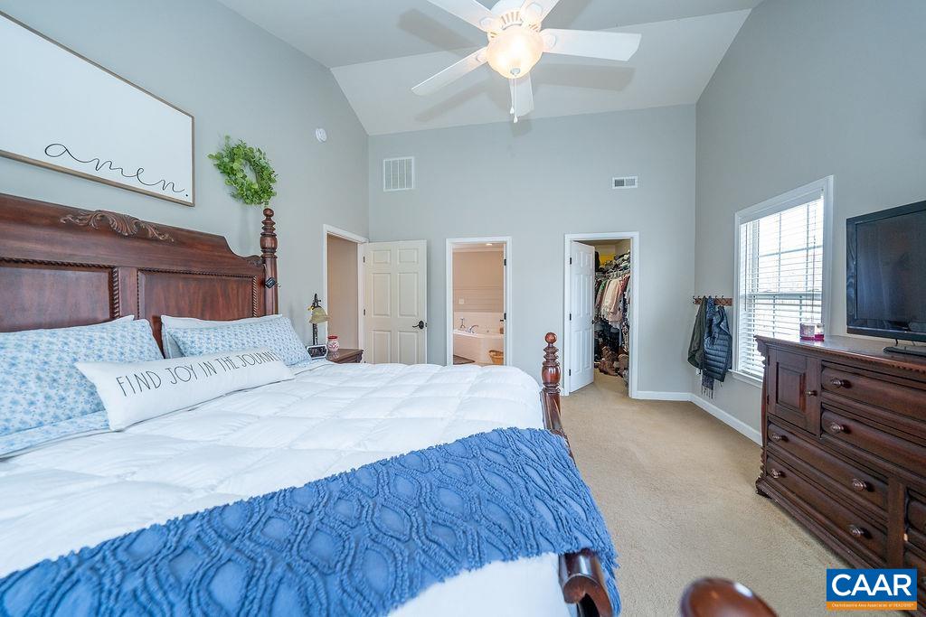 60 Pine Ridge Road Faber, VA 22938 - Photo 45 of 74 a spacious bedroom with a bed and a chandelier