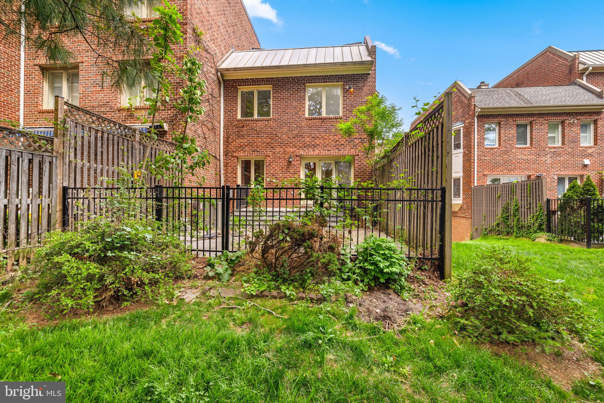 4018 Chancery Court Northwest Washington, DC 20007 - Photo 43 of 43 a view of a house with brick walls and a flower garden